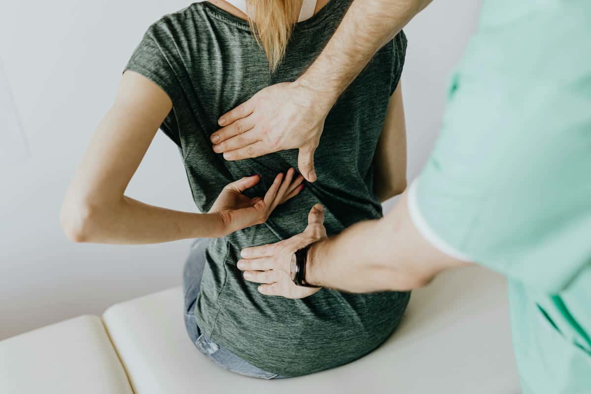 Mujer con dolor de espalda en fisioterapeuta